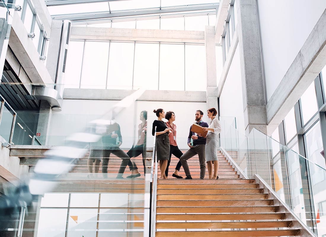 Review Our Agency - Group of Business People Standing in the Hallway Chatting