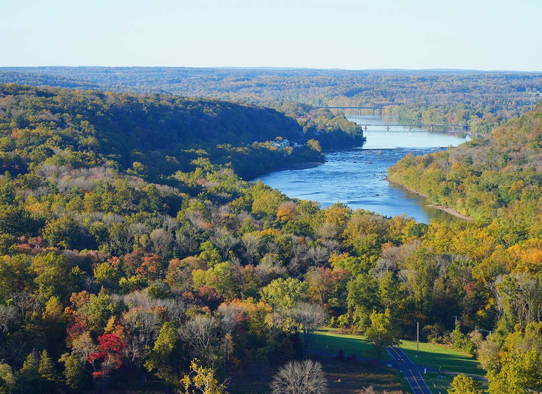 Contact - Aerial View of a River Surrounded by Green Trees on a Sunny Day in the Early Fall in Pennsylvania